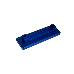 A small metallic blue rectangular tool or accessory with a recessed channel, placed on a round off-white display surface against a white background.