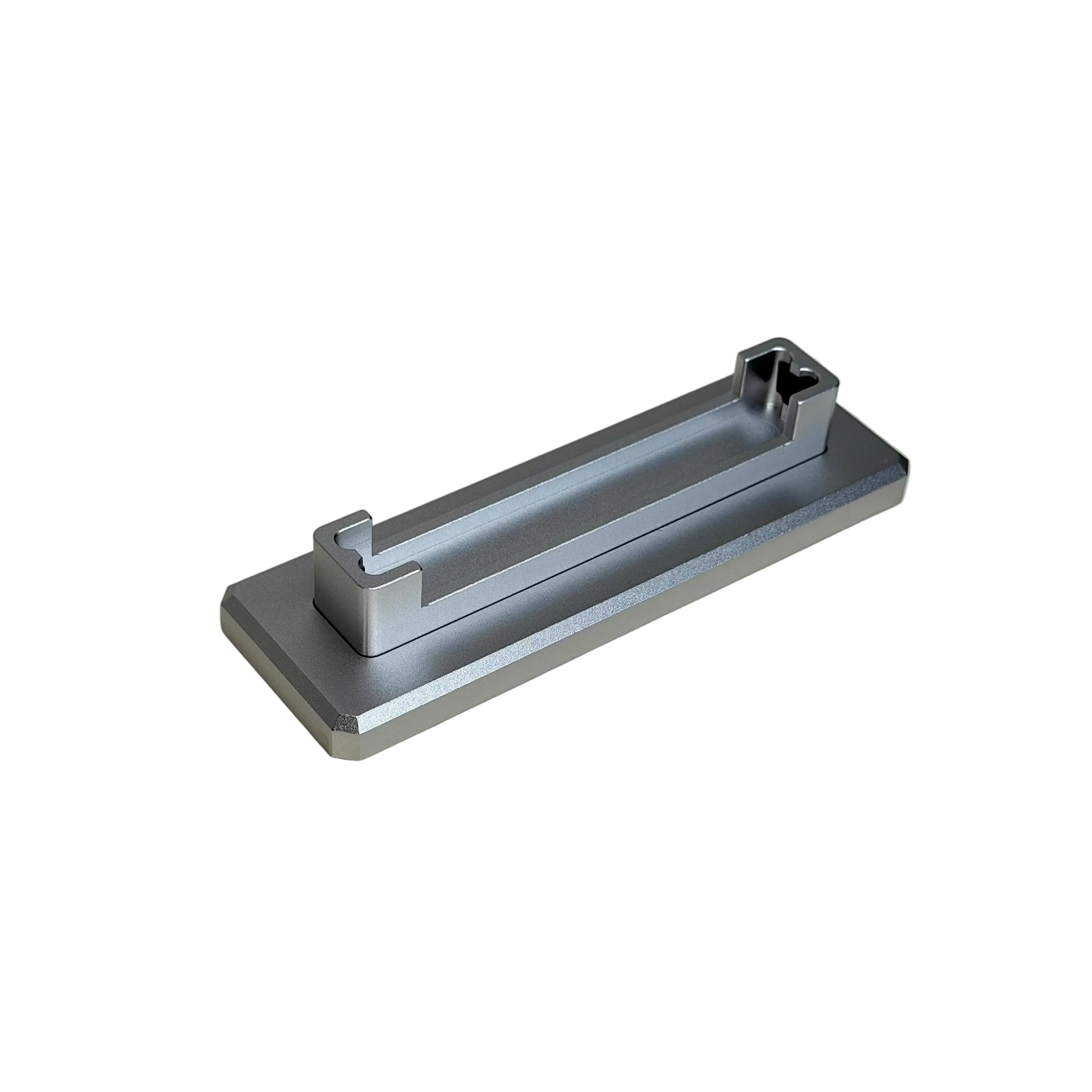 A silver metallic rectangular handle with a square cross-section, resting diagonally on a round beige ceramic plate.