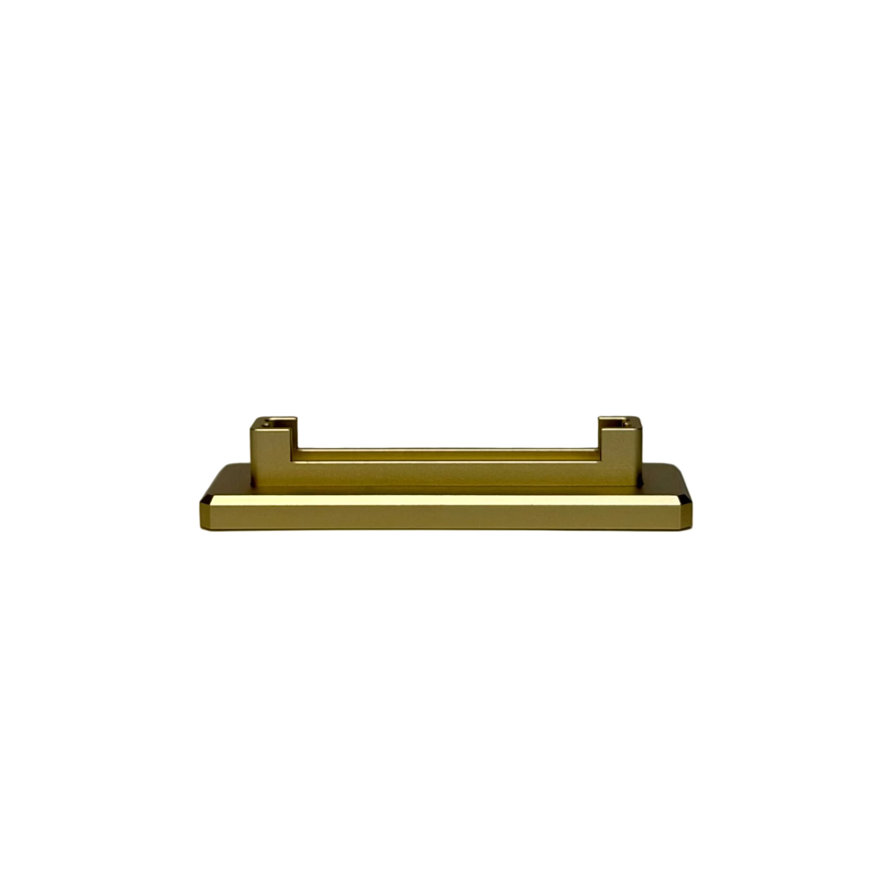 A modern rectangular gold metal cabinet pull handle displayed on a round white pedestal against a textured gray background.